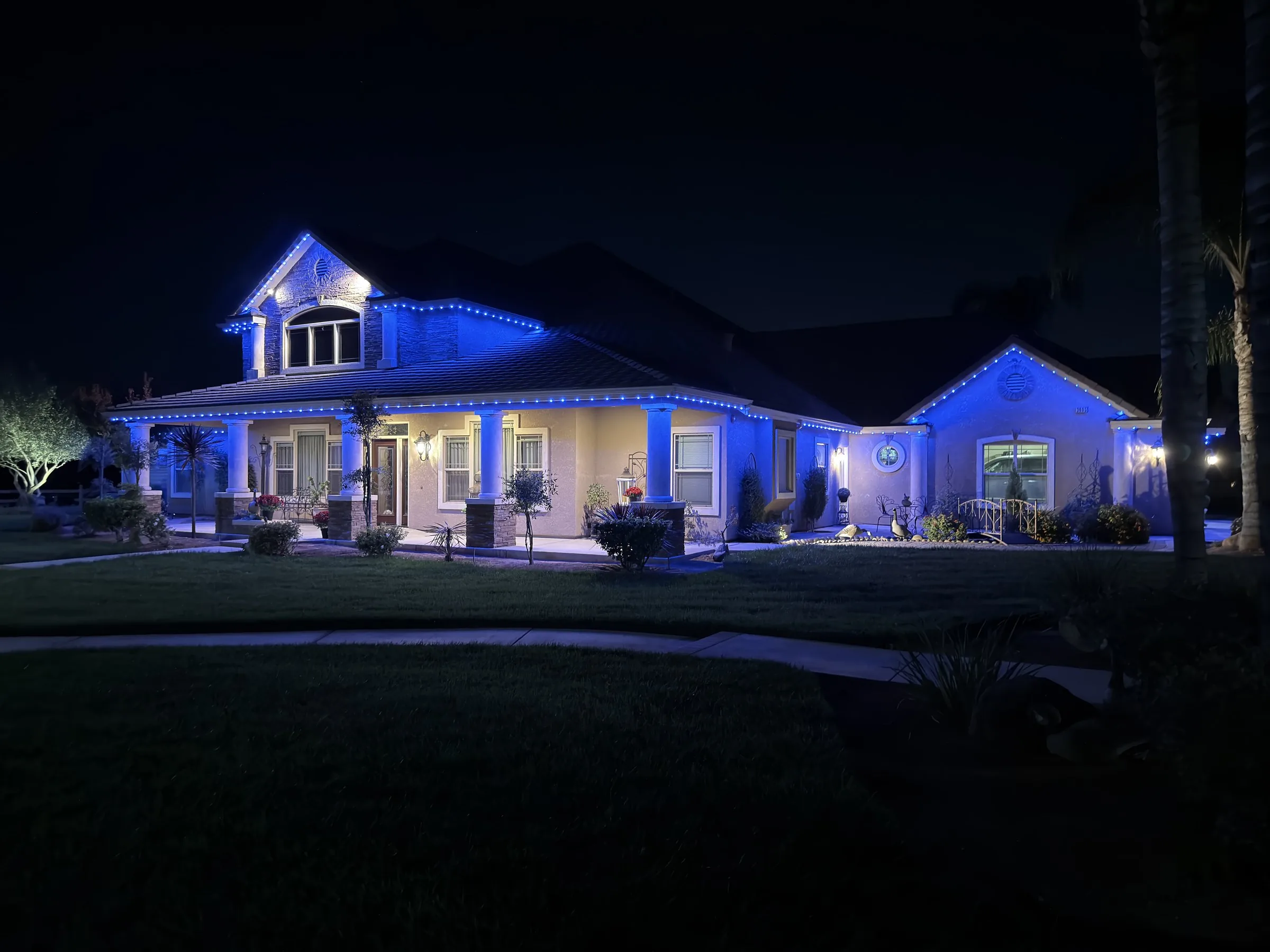 The same home at night with Halo roofline lighting in deep blue