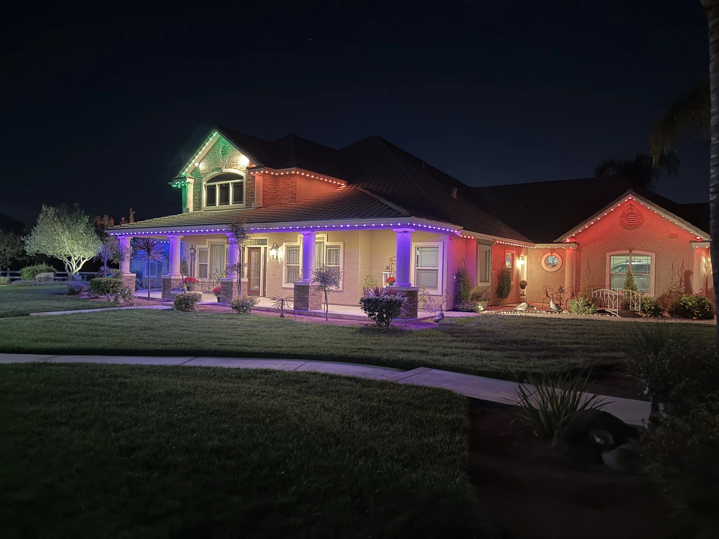The same home at night with Halo roofline lighting in purple, green, and orange zones