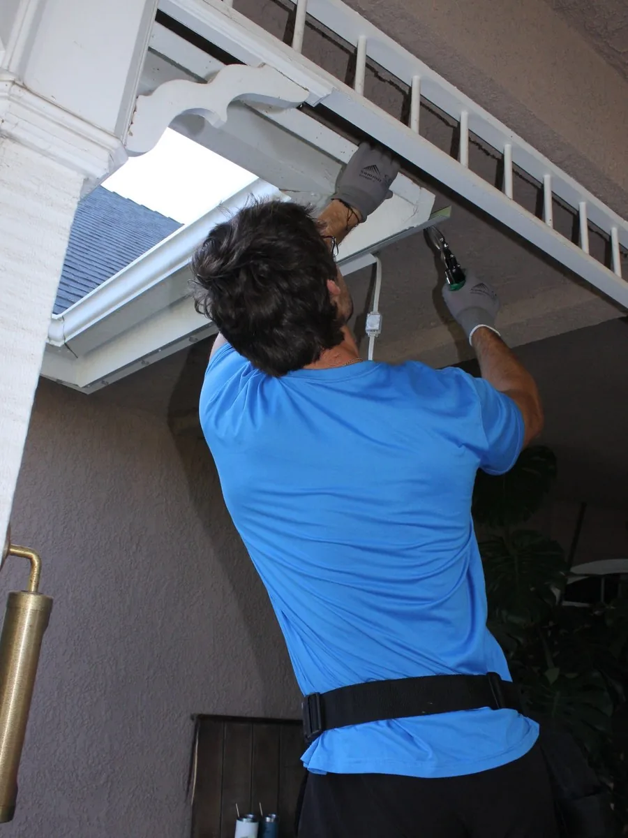 Halo Exterior installer mounting lighting channel under the eave of a Clovis home