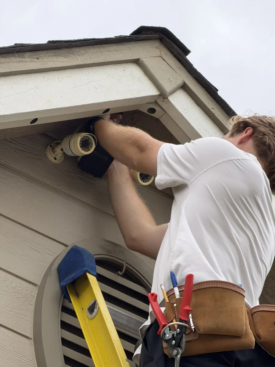 Close view of an installer aligning a roofline light fixture by hand