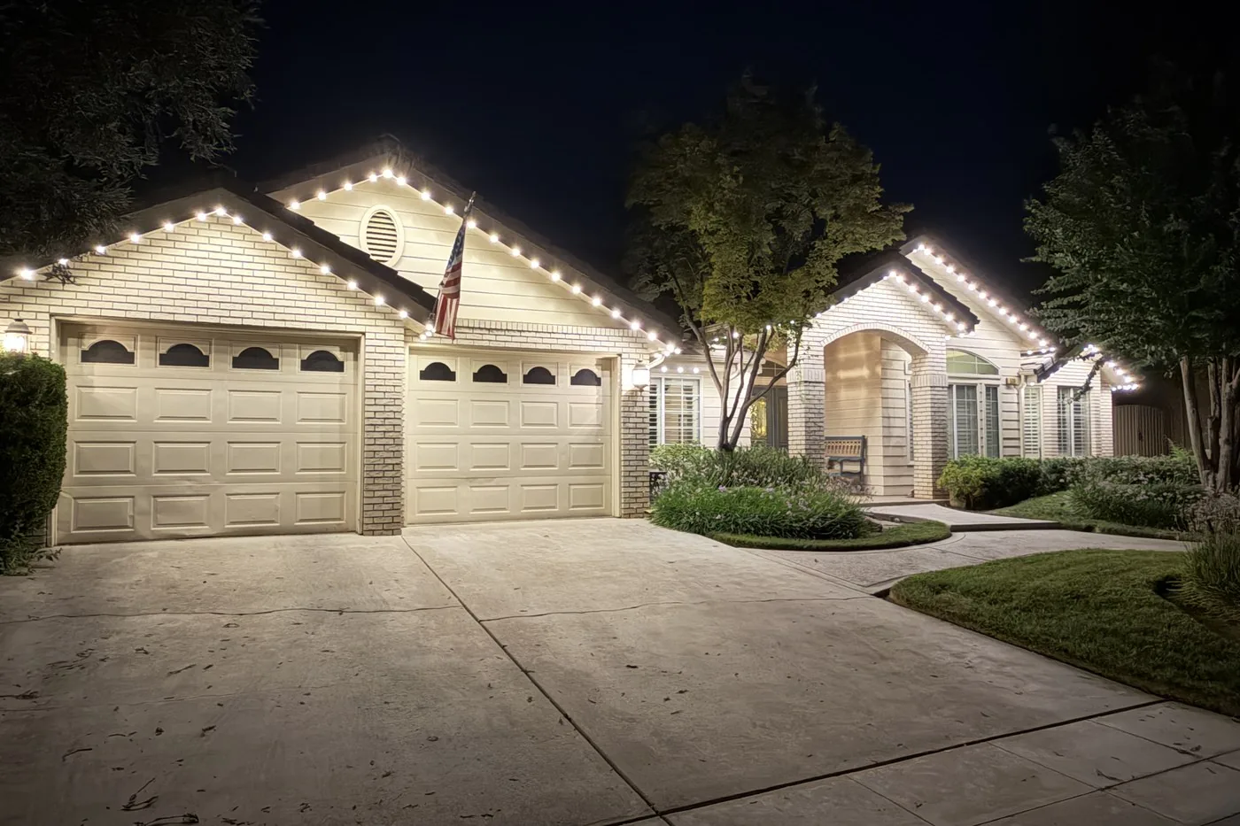 The same Clovis home moments later, unedited, warm white roofline lighting